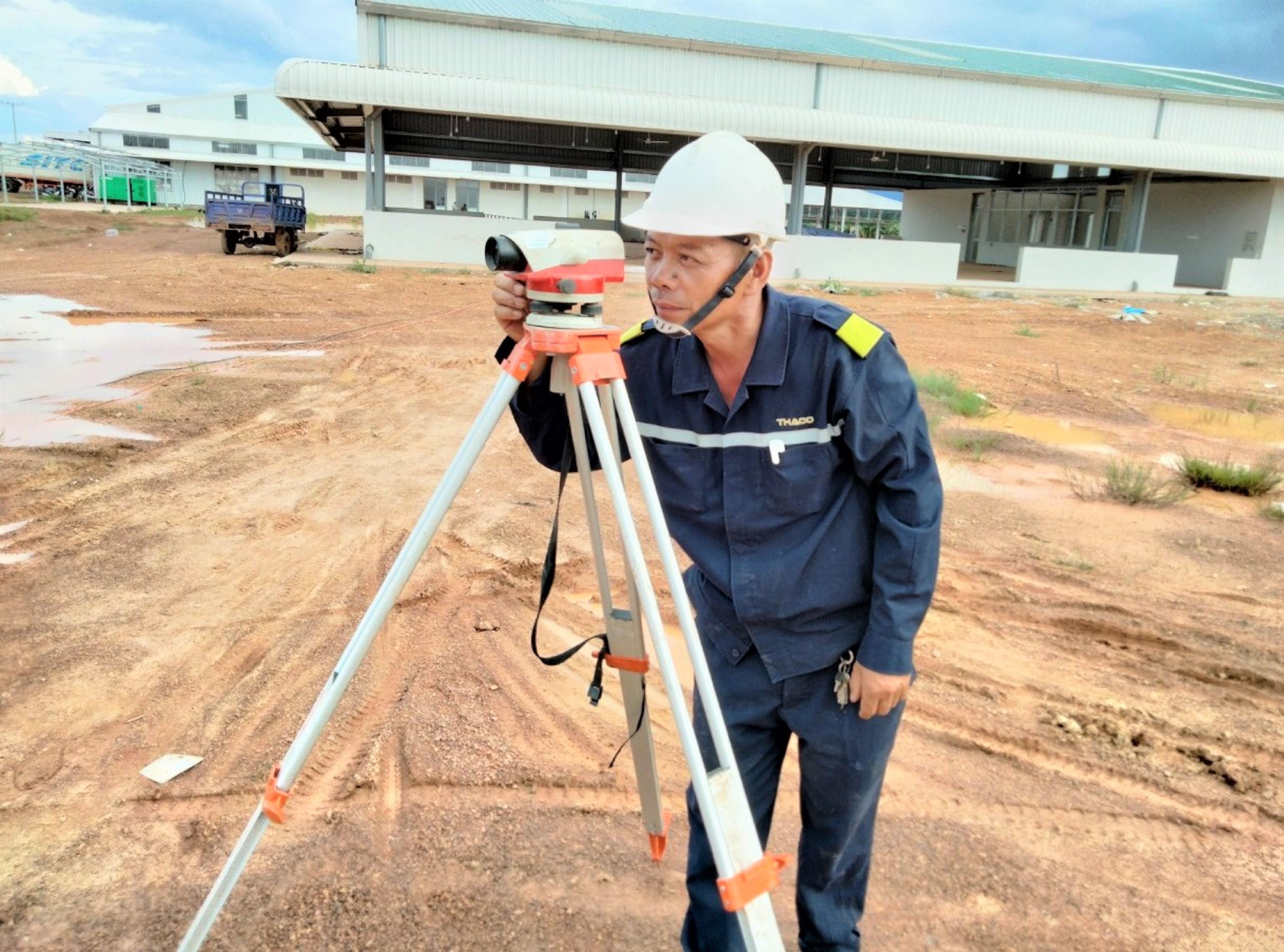 4. Anh Nguyễn Tất Qua đang kiểm tra cao độ để san lấp mặt bằng.jpg